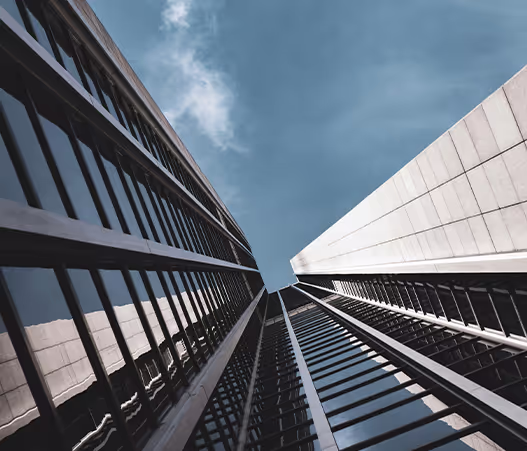 A low-angle view of a modern skyscraper with reflective glass windows.

